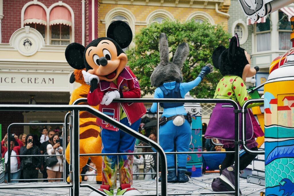 Vibrant Disneyland Paris parade with iconic Disney mascot characters entertaining the crowd.